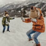 момчета изграещи в снега със зимни якета