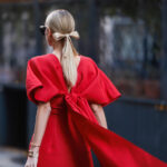 Как да се облечете за Коледа - жна с елегантна червена дълга рокля с панделка отзад