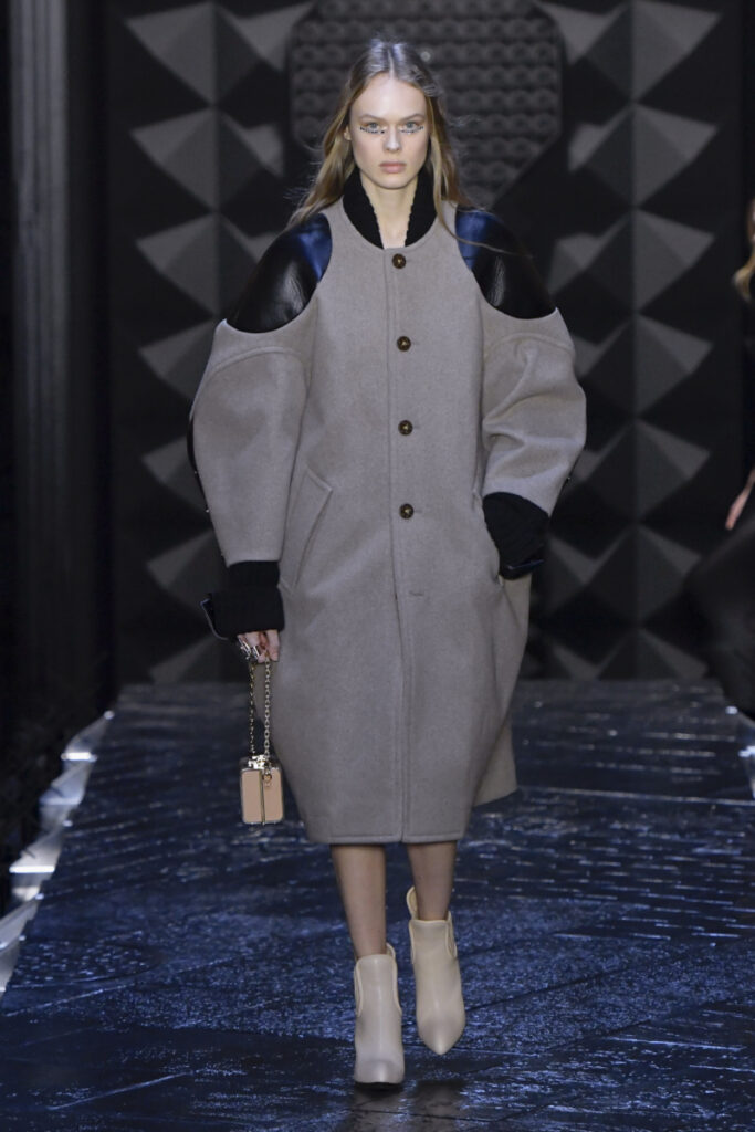 Модел на модно ревю със сиво вълнено палто с кожени елементи