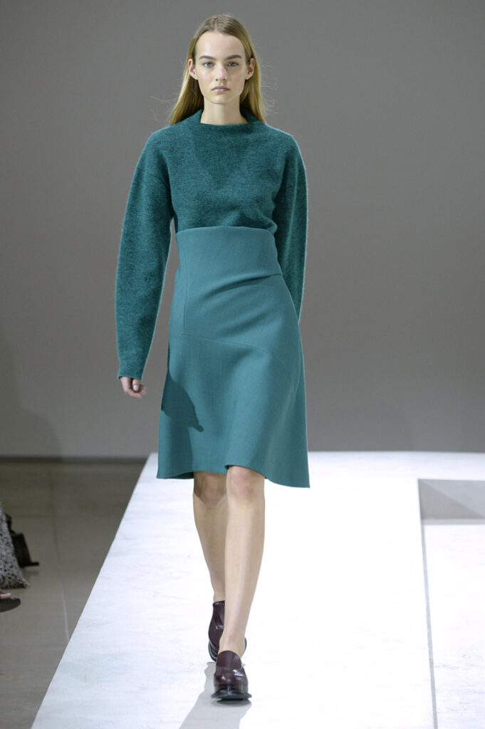 модел от модно ревю на Jil Sander с рокля в петролен цвят