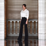 Victoria Beckham носи бяла риза и черен панталон с висока талия